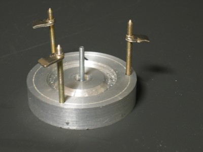 In the centre hole is a simple screw, the three screws at the side are from an distribution box for electrical installation in hollow walls. These screws have a wing instead of a nut and enables a good fixation of the rim.The disc was a flat groove turned (35 mm diameter for 16 inches wheels in scale 1/12 )The centre boring got a 8mm deepening for the smaller outside of the hub.